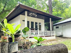 A two-story building with a porch, surrounded by lush greenery. - Vongdeuan Resort (Rayong)