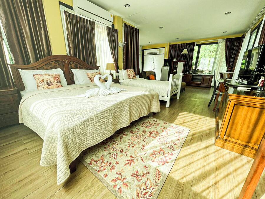 Una habitación de hotel con una cama grande, un escritorio, una silla y un televisor.