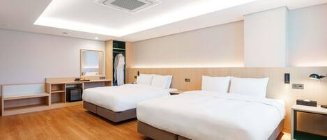A modern hotel room with two beds, a walk-in closet, a vanity with a mirror, and a ceiling light fixture.
