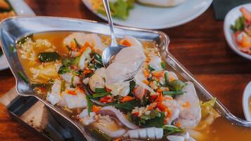 A dish with seafood and vegetables in a metal serving dish.