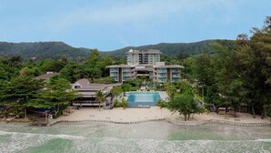 A resort with a large pool, multiple buildings, and a mountainous backdrop. - Sand Dunes Chaolao Beach Resort (Tha Mai)