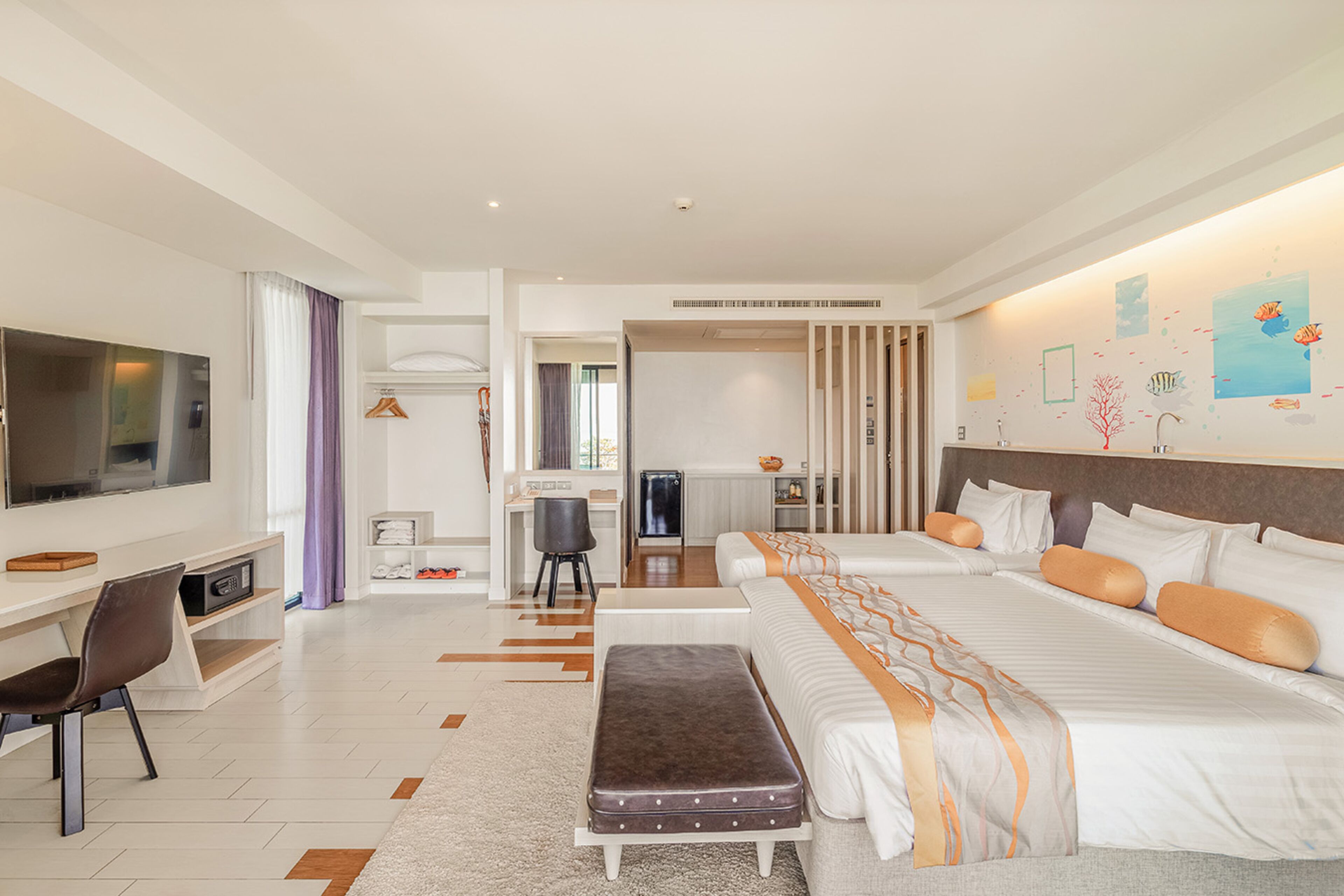 Een moderne hotelkamer met een groot bed, een bureau, een televisie en een badkamer die door een geopende deur zichtbaar is.