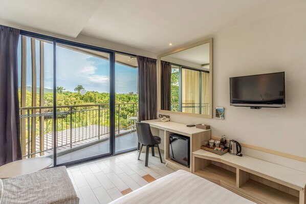 A hotel room with a large balcony, a desk, a bed, and a TV. - Sand Dunes Chaolao Beach Resort (Tha Mai)