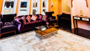 A spacious lobby with a high ceiling, a chandelier, and a seating area with sofas and armchairs. - Baron Zotel Bangkok (Bangkok)