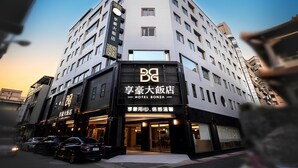 A multi-story hotel with a prominent sign for "HOTEL BONZA" and a parking area with several cars. - Hotel Bonza (Zhubei)