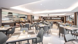 A modern restaurant with a buffet, multiple seating areas, and a bar. - Hotel Bonza (Zhubei)