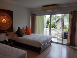 A bedroom with a bed, a nightstand, a wall decoration, and a view of the outside.