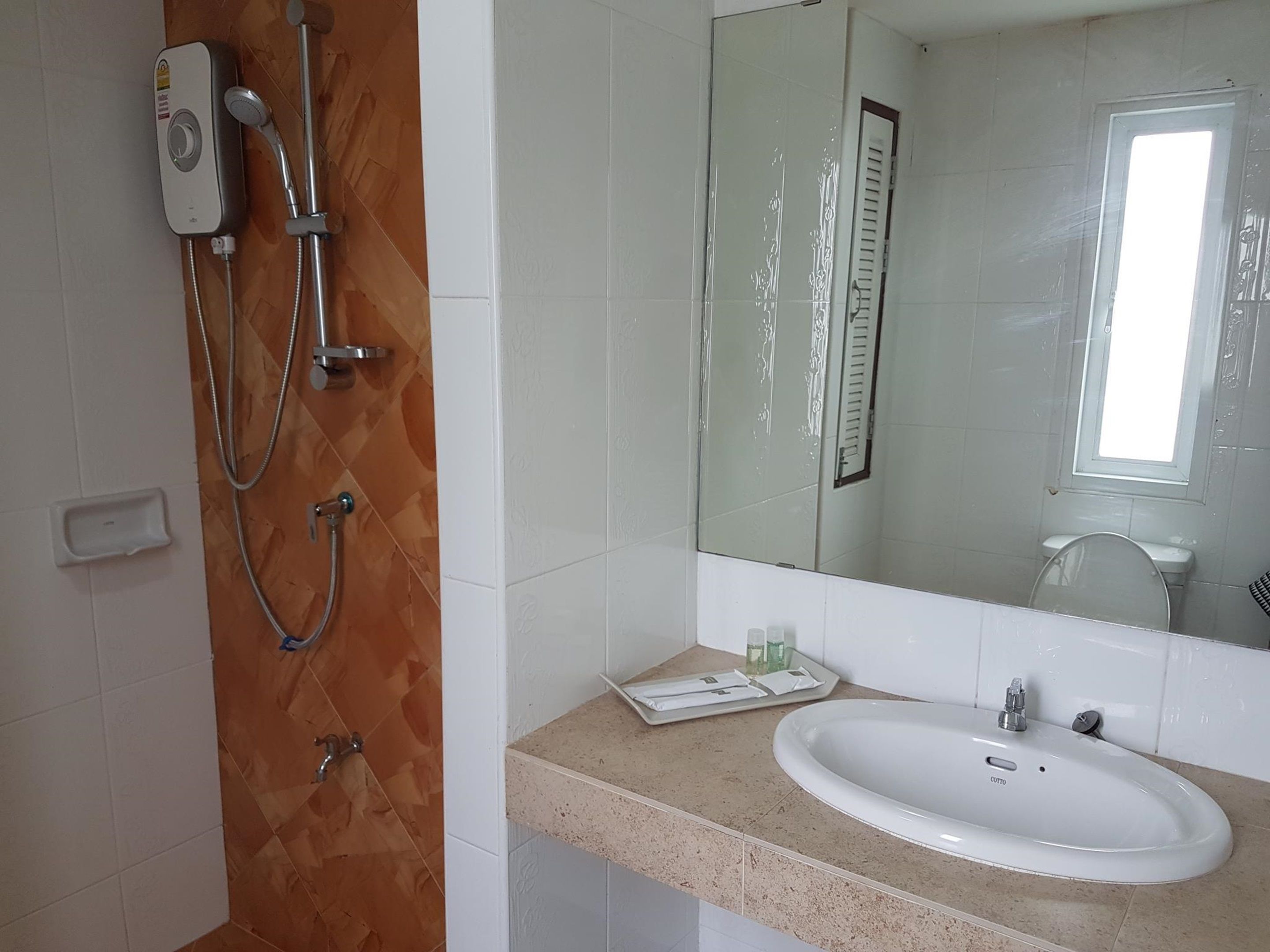 Ein Badezimmer mit Dusche, Waschbecken und Spiegel.