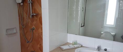 Ein Badezimmer mit Dusche, Waschbecken und Spiegel.