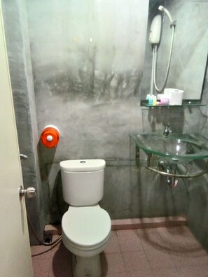 A bathroom with a toilet, a glass sink, and a shower. - Wild & Wandering Backpacker & Bar (Ko Pha-ngan)