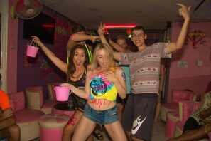A room with pink walls, a white ceiling fan, and a sign prohibiting food. - Wild & Wandering Backpacker & Bar (Ko Pha-ngan)