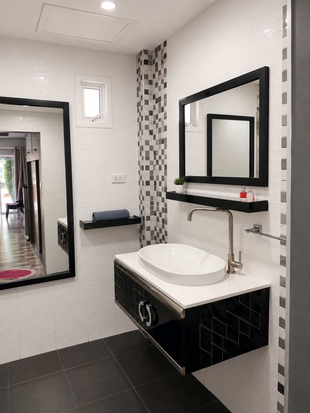 A modern bathroom with a white sink, black cabinet, and a checkered wall pattern.