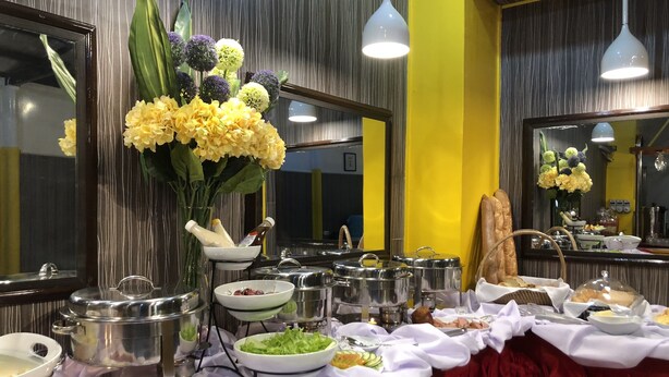 Una taula de buffet amb diferents aliments, com ara fruita, verdura i botifetes.