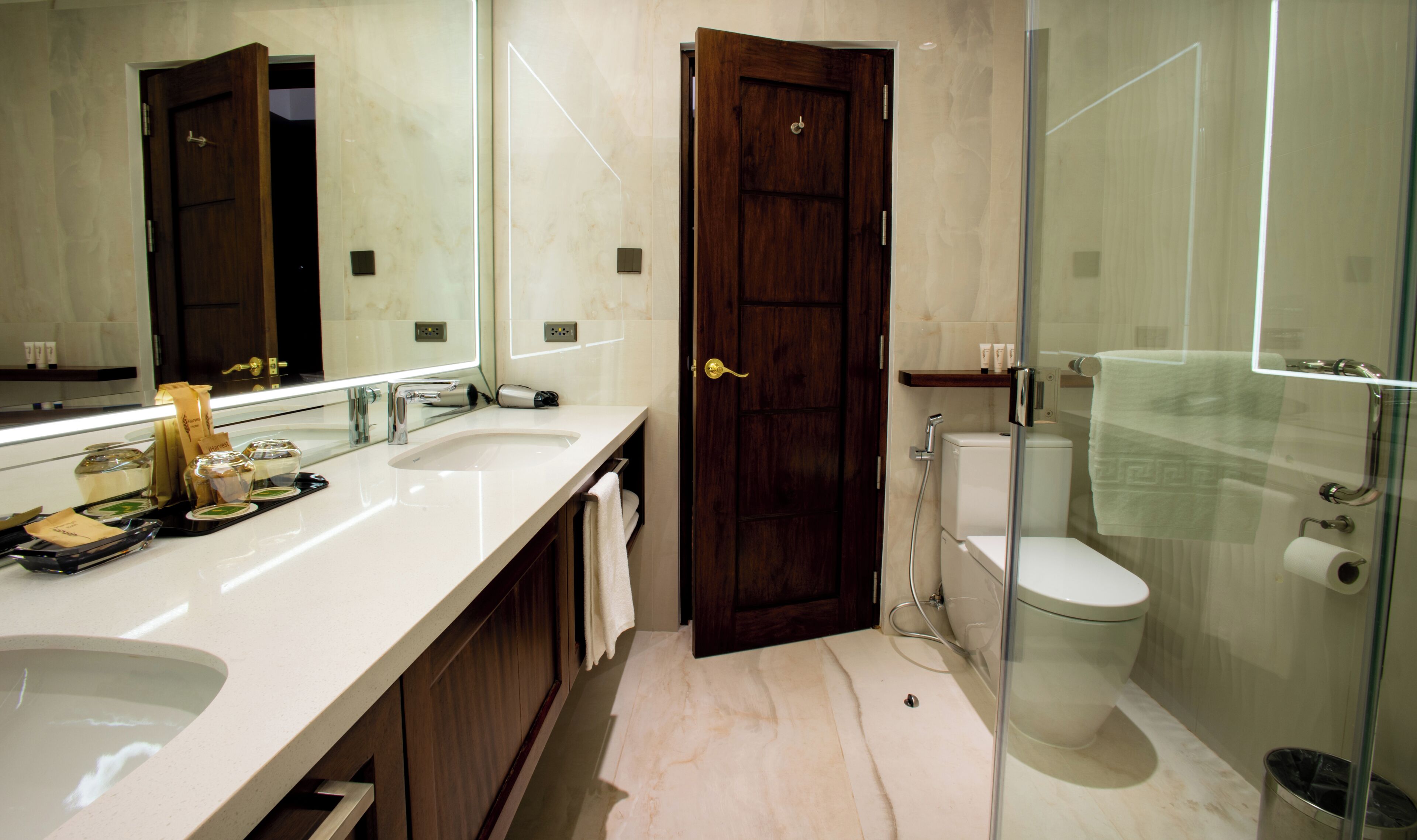 A modern bathroom with a large mirror, a sink, a toilet, and a shower area.