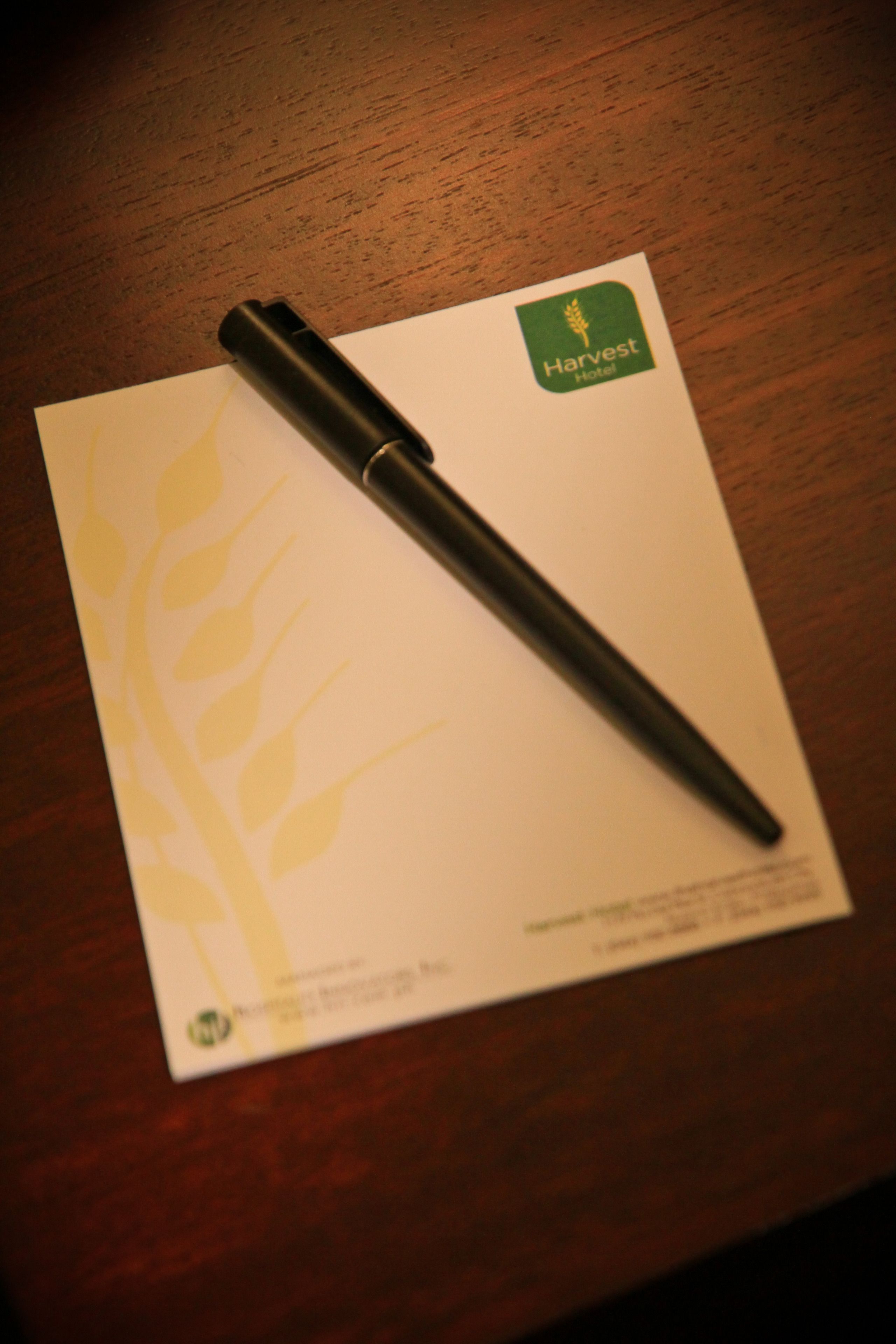 Caneta sobre papel com o logotipo do Harvest Hotel.