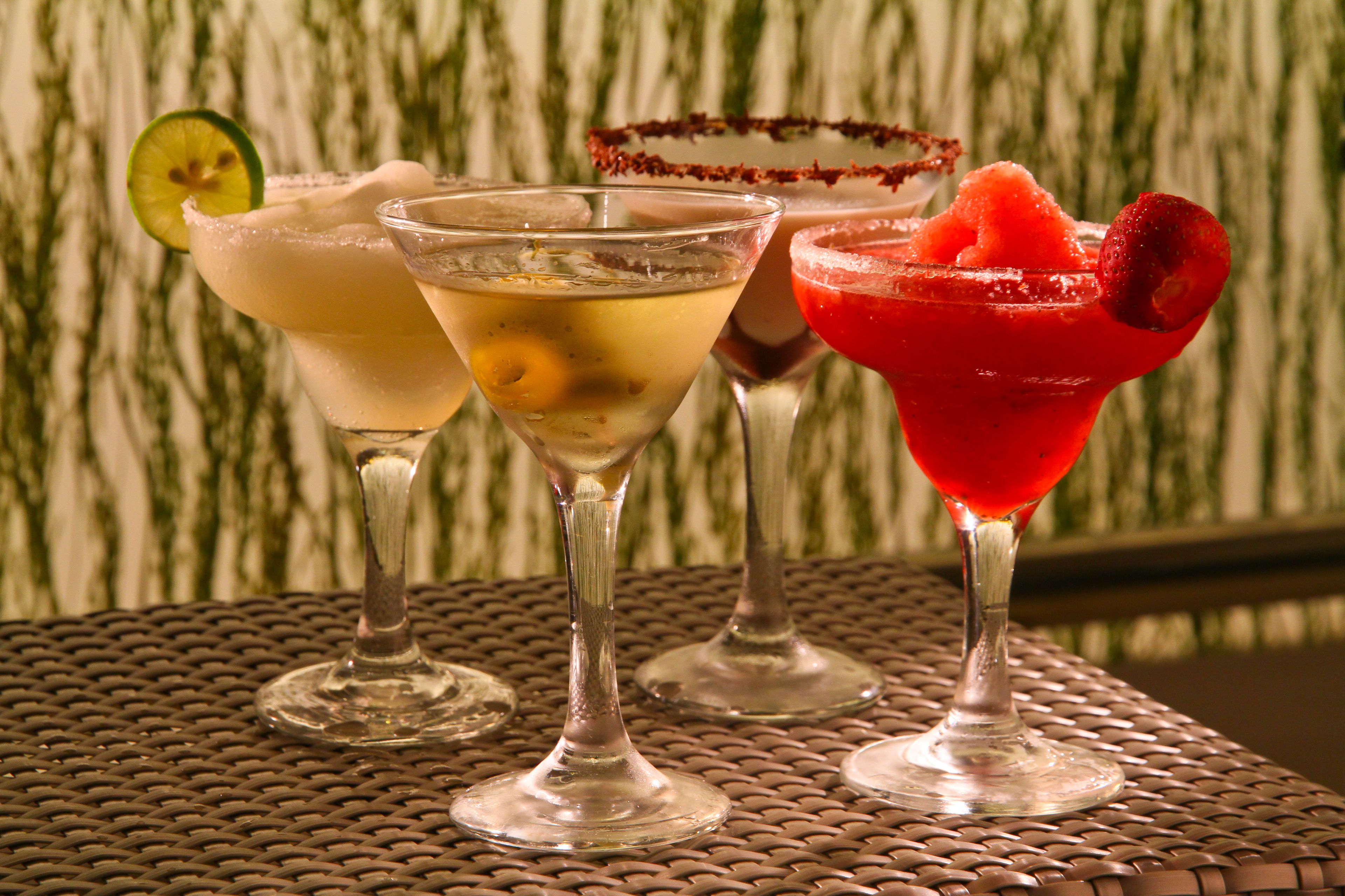 Tre cocktail su un tavolo di metallo con motivo intrecciato.