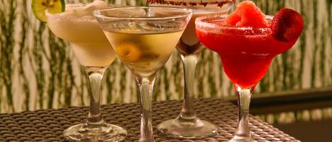 Tre cocktail su un tavolo di metallo con motivo intrecciato.