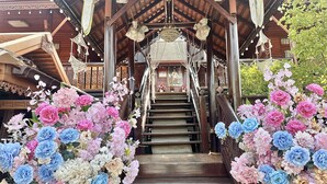 A wooden staircase with floral decorations on either side, leading to a covered area with a chandelier. - Montri Resort Donmuang Bangkok (Bangkok)