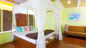 Un dormitorio con cama con dosel, un sofá y un cuadro en la pared.