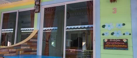 A room with a large window, a wooden bench, and a wall-mounted clock.