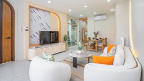 Una sala de estar moderna con sofá, mesa de centro y televisor.