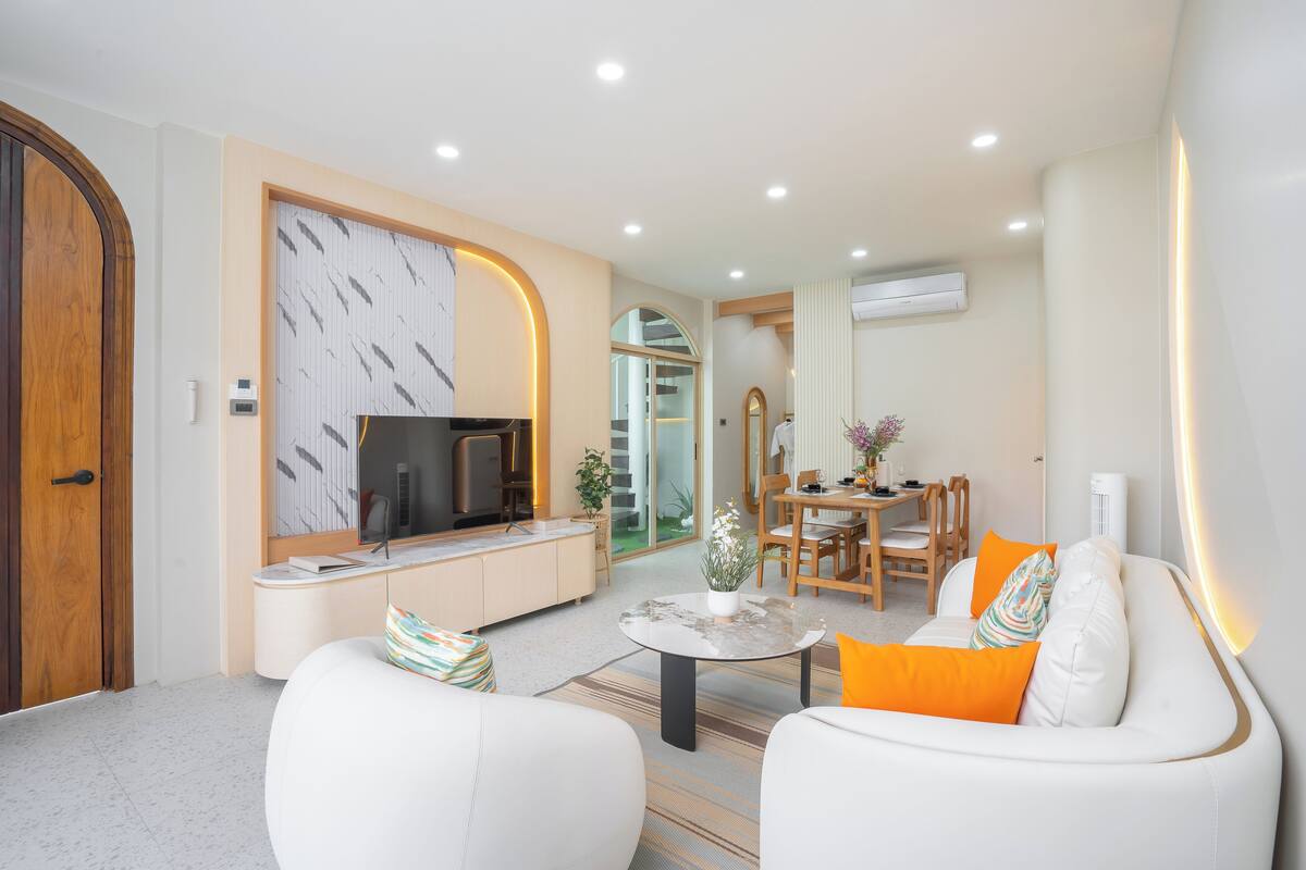 A modern living room with a sofa, coffee table, and a TV.