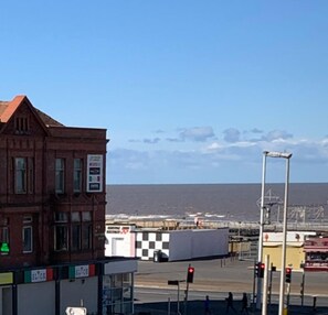 A coastal view with a red brick building, a checkered awning, and a clear sky. - Danescourt Lodge (Blackpool)