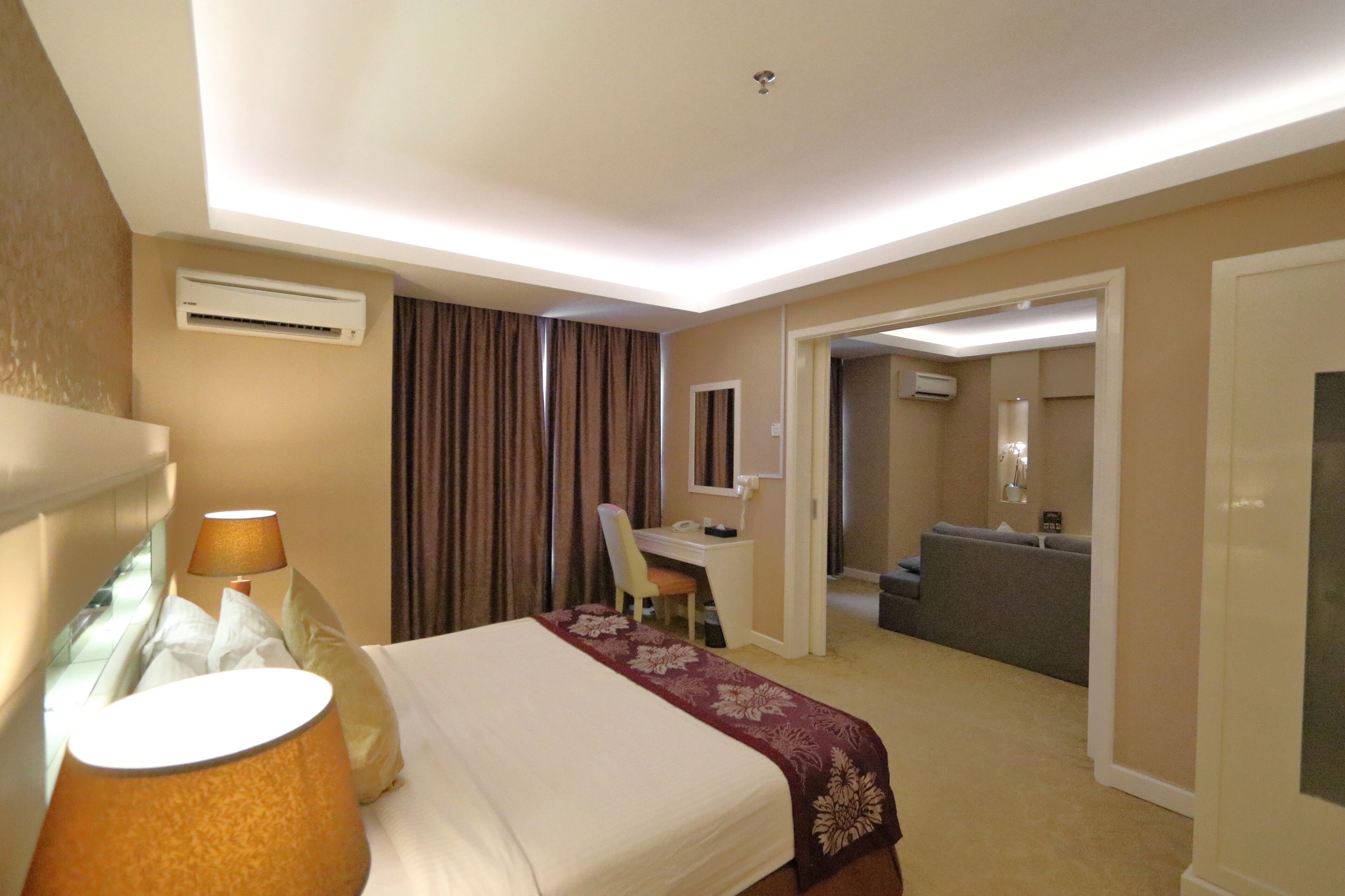 Una habitación de hotel con cama, escritorio, silla y sofá.