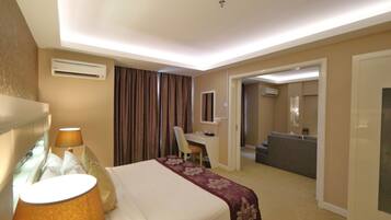 Una habitación de hotel con cama, escritorio, silla y sofá.