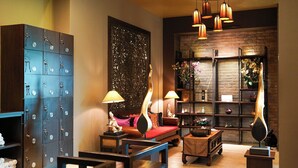 A cozy living room with a sofa, a decorative wall, a cabinet with numbered compartments, and a brick fireplace. - The Guest Hotel & Spa (Port Dickson)