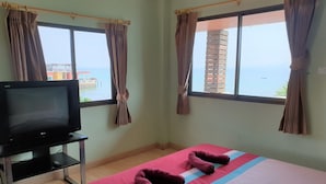A hotel room with a bed, a TV, and curtains. - Sea Beach Koh Larn 2 (Koh Lan)