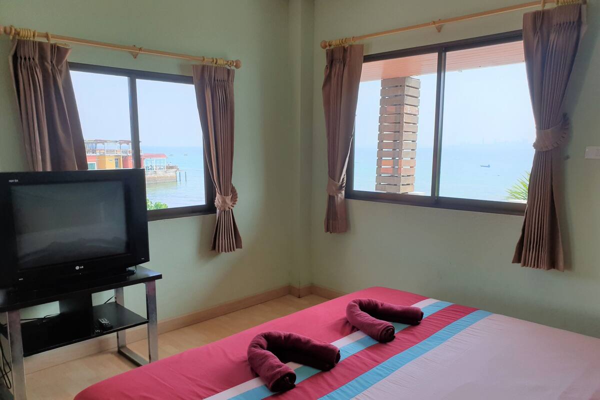 A hotel room with a bed, a TV, and curtains.