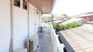 A balcony with a view of neighboring houses and a hilly landscape. - Sea Beach Koh Larn 2 (Koh Lan)