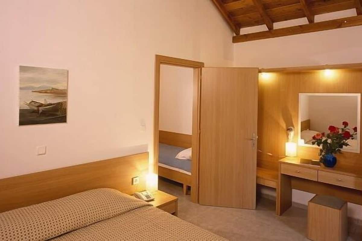 A bedroom with a bed, bedside table, and a mirror.