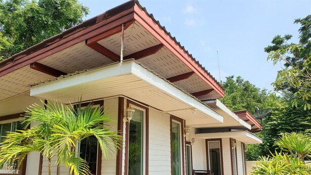 A two-story house with a red roof, large windows, and a small porch with a chair. - Sea Beach Koh Larn 3 (Koh Lan)