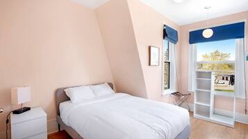 Ein Schlafzimmer mit Bett, Nachttisch, Fenster mit Blick und einer integrierten Ablage.