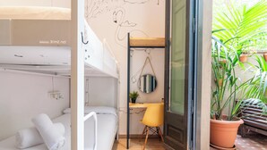 A compact room with a bunk bed, a desk with a chair, a round mirror, and a potted plant. - The Central House Barcelona Gracia - Hostel (Barcelona)