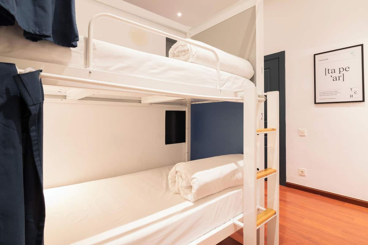 A bunk bed room with a framed sign on the wall and a door to the right.