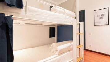 A bunk bed room with a framed sign on the wall and a door to the right.