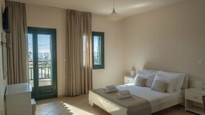 A bedroom with a bed, bedside tables, a window, and a door.