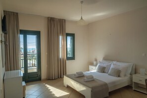 A bedroom with a bed, bedside tables, a window, and a door.
