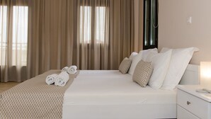 A hotel room with a large bed, a bedside table, and a window with curtains.