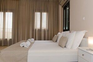 A hotel room with a large bed, a bedside table, and a window with curtains.