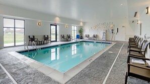 A large indoor swimming pool with clear water, surrounded by lounge chairs and a tiled floor. - Sleep Inn & Suites Ames near ISU Campus (Ames)