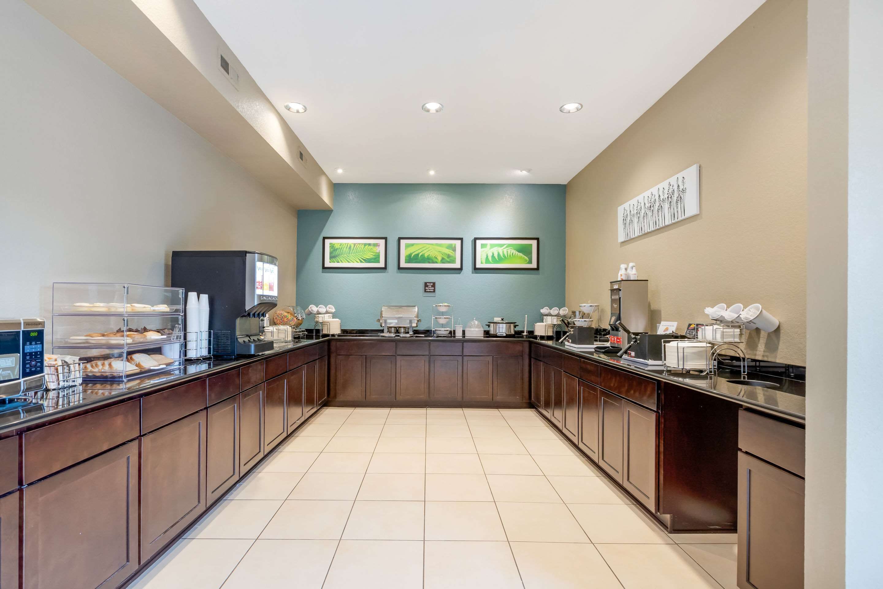 Una cocina moderna con una isla central, electrodomésticos integrados y una zona para preparar café.