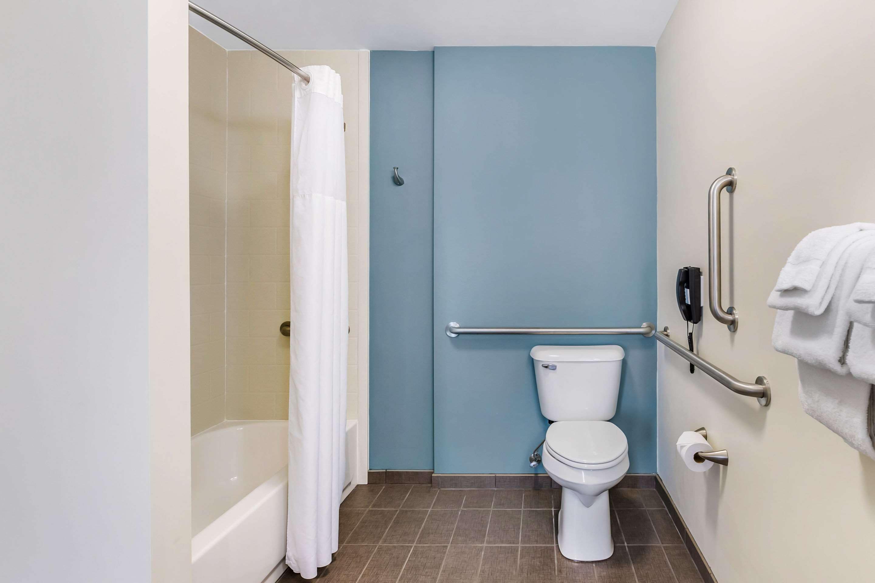 Een badkamer met een bad, toilet en douchegordijn.