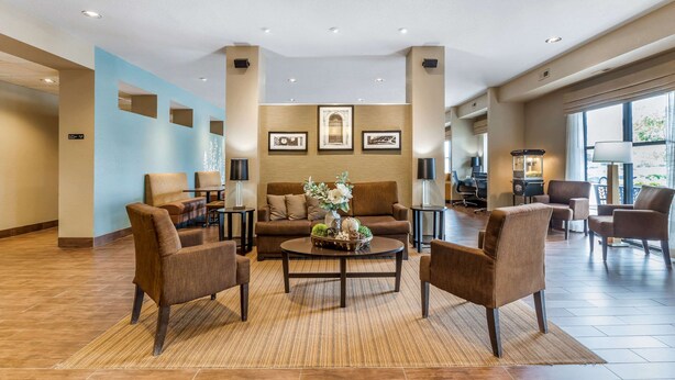 A spacious lobby with a brown sofa, armchairs, and a coffee table. - Sleep Inn & Suites Ames near ISU Campus (Ames)