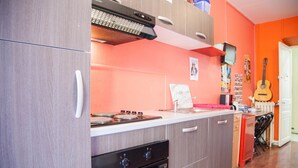 Una cocina con armarios de madera, estufa a gas y microondas.