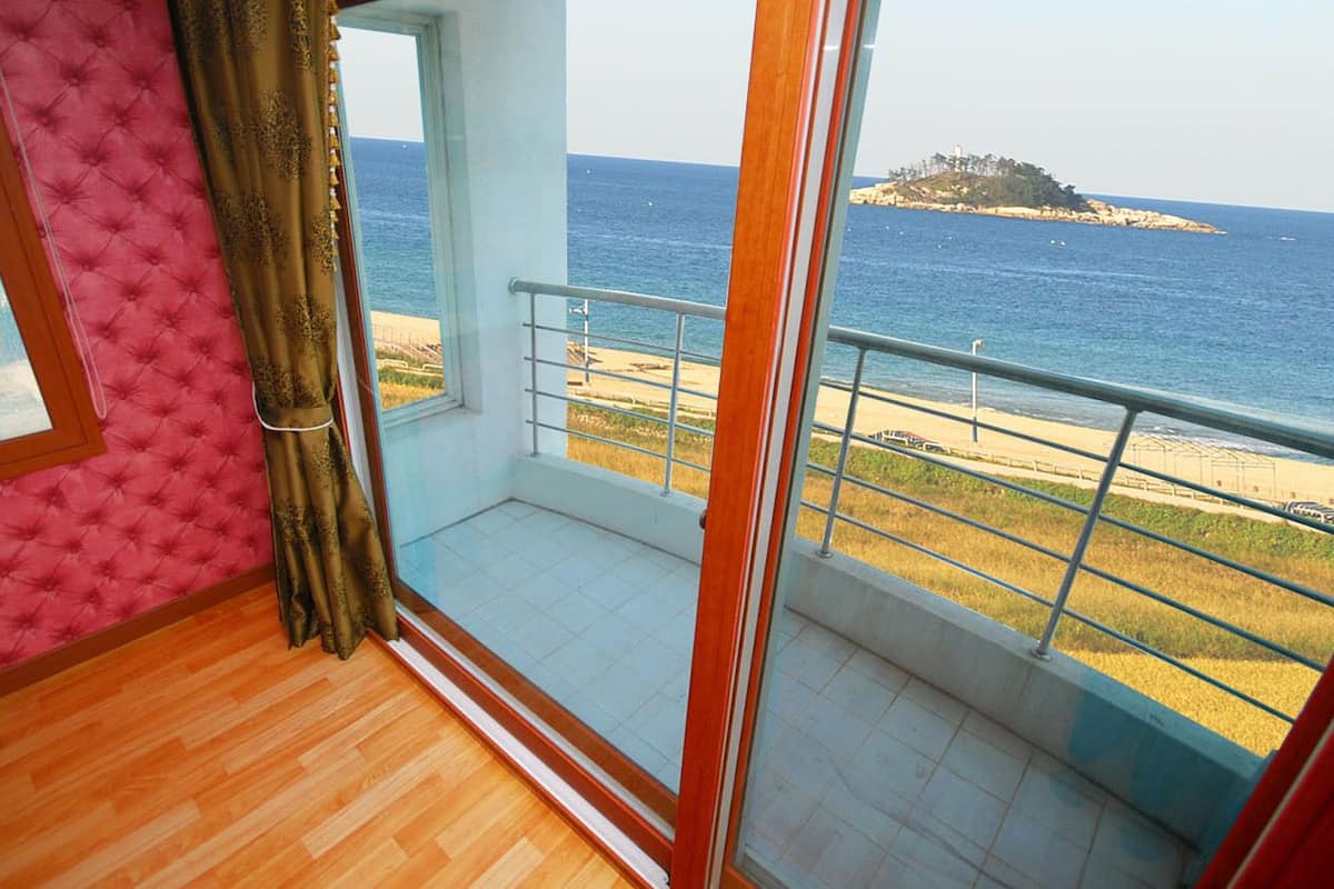 Un balcón con vista al mar y una isla distante.