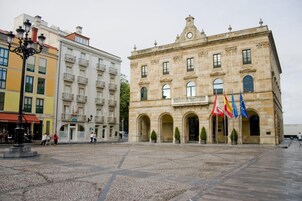 Edificio histórico con patio central, que destaca por una entrada con arcos y banderas.